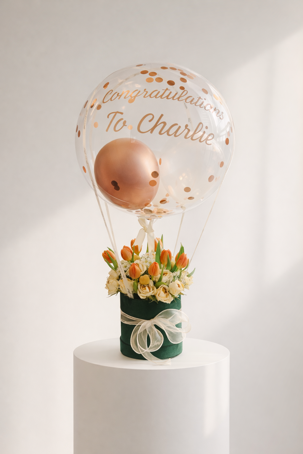 Decorative balloon with flowers on a white pedestal against a light background